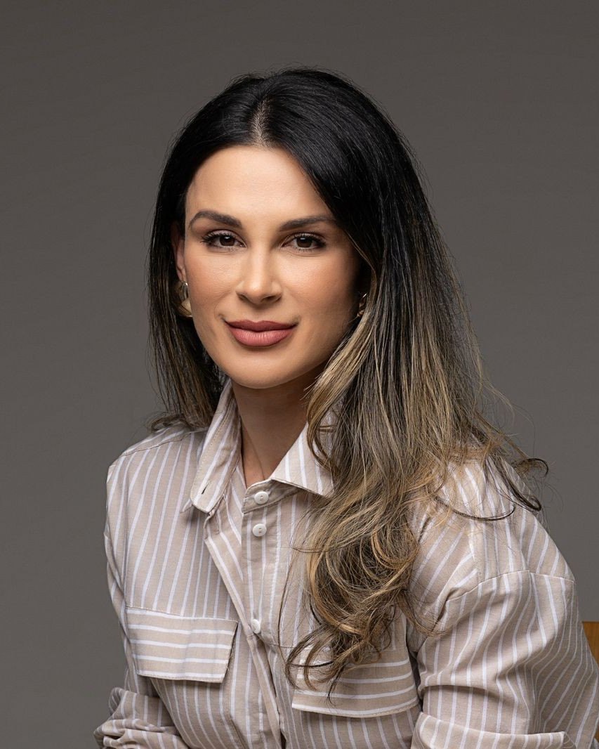 Retrato da nutricionista Joyce Ávila, de camisa listrada, sorrindo